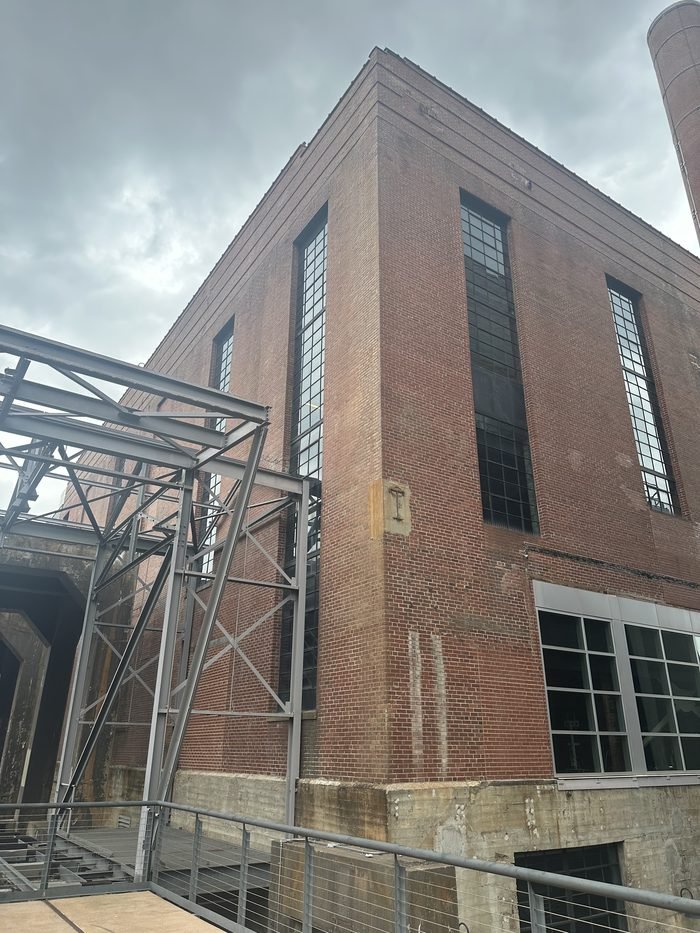 Historic brick industrial building with exterior steel bracing under evaluation