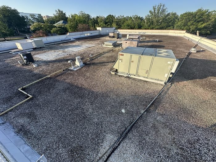 Ballasted roof with a packaged rooftop unit and its supporting curbs